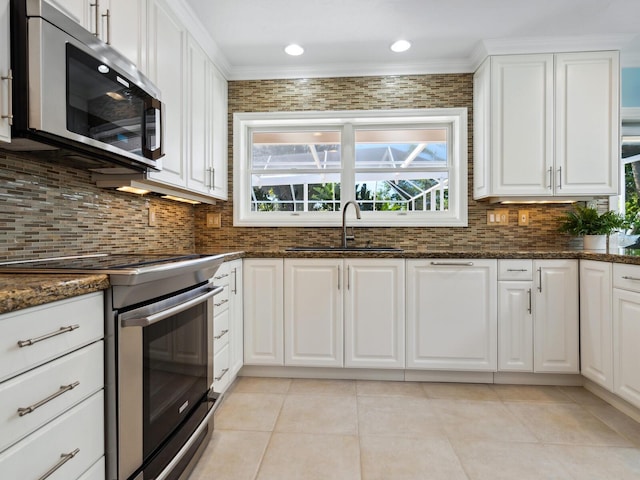 kitchen with sink, white cabinets, dark stone counters, and appliances with stainless steel finishes