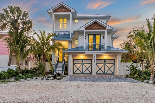 coastal inspired home with a balcony and a garage