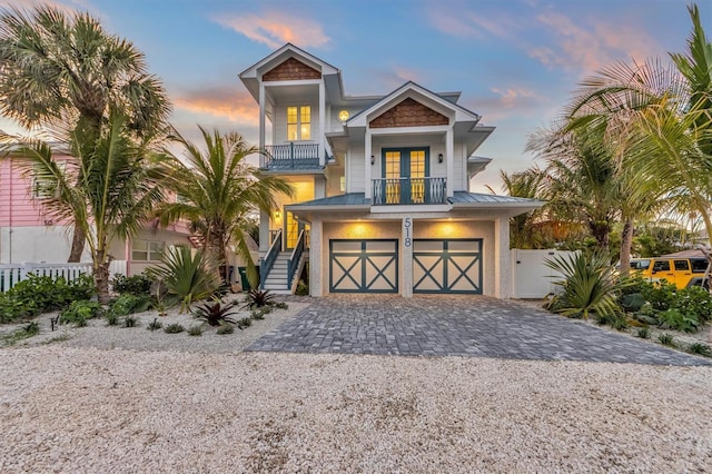 view of front of property with a garage, a balcony, and french doors