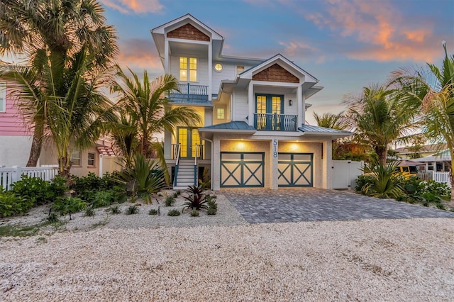 view of front of property featuring french doors, a balcony, and a garage