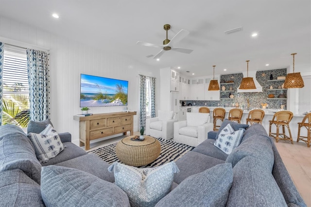 living room featuring ceiling fan, a healthy amount of sunlight, and light hardwood / wood-style floors