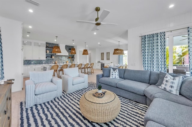 living room featuring ceiling fan, a healthy amount of sunlight, and light hardwood / wood-style floors