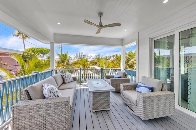 wooden terrace with an outdoor living space and ceiling fan