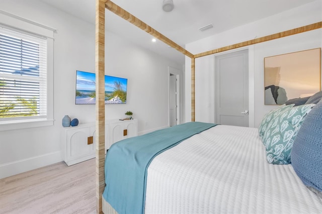 bedroom with light hardwood / wood-style flooring and multiple windows