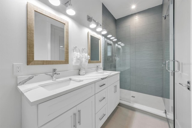 bathroom featuring a shower with door and vanity