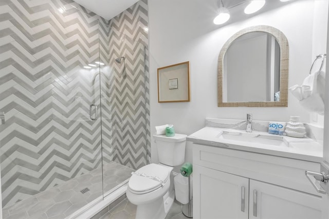 bathroom featuring tile patterned floors, toilet, an enclosed shower, and vanity