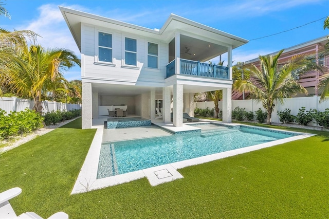 back of house with outdoor lounge area, ceiling fan, a balcony, a yard, and a patio