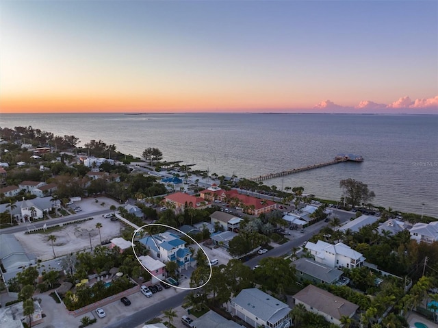 aerial view at dusk featuring a water view