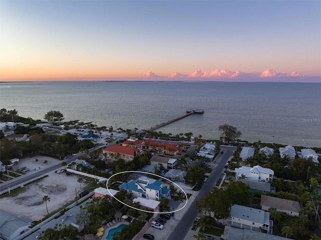 aerial view at dusk featuring a water view