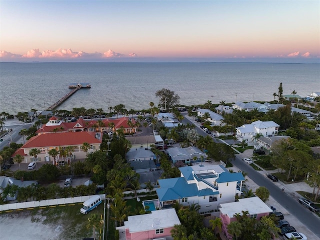 aerial view at dusk featuring a water view