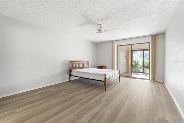 unfurnished bedroom with ceiling fan, access to exterior, wood-type flooring, a textured ceiling, and a closet