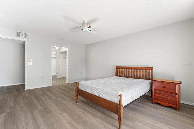 bedroom featuring ceiling fan, hardwood / wood-style floors, and a textured ceiling