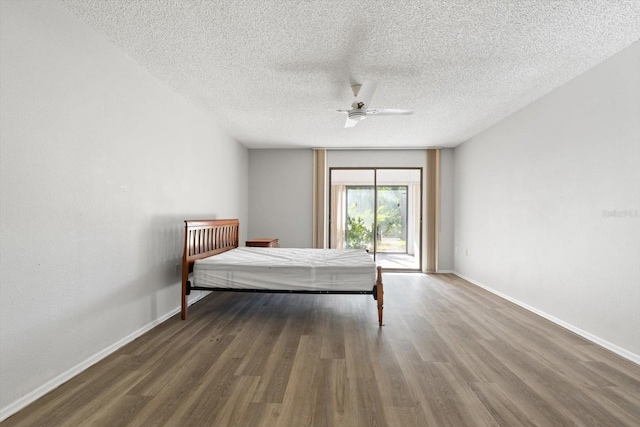 unfurnished bedroom with dark hardwood / wood-style floors, a textured ceiling, and ceiling fan