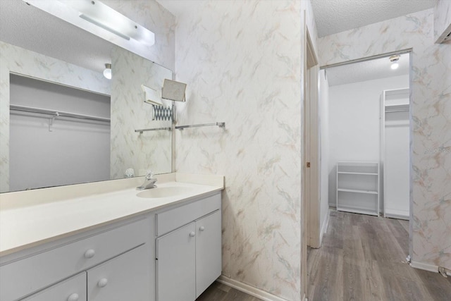 bathroom featuring hardwood / wood-style flooring, vanity, and a textured ceiling