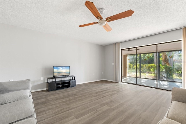 unfurnished living room with ceiling fan, hardwood / wood-style floors, and a textured ceiling