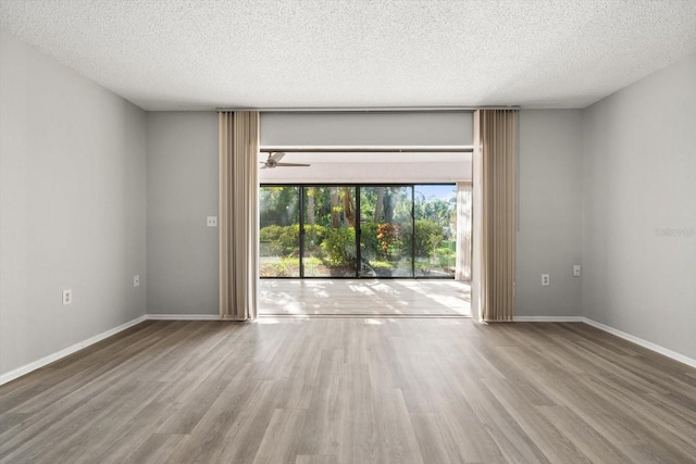 unfurnished room with wood-type flooring, ceiling fan, and a textured ceiling