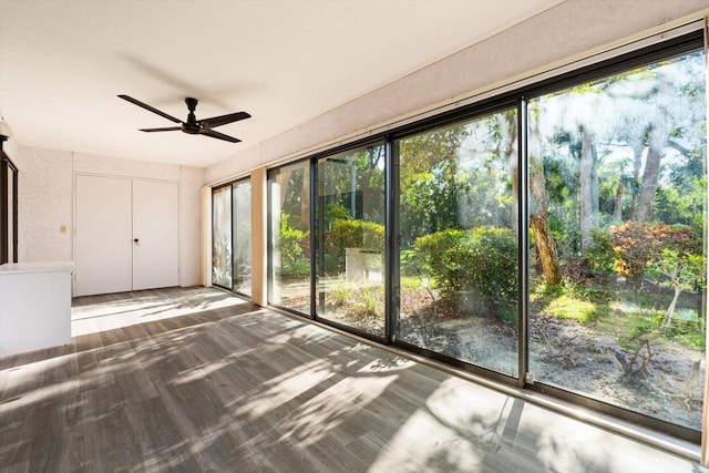 unfurnished sunroom with ceiling fan