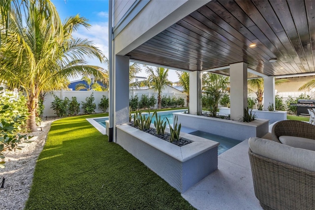 view of patio with a fenced in pool and a grill