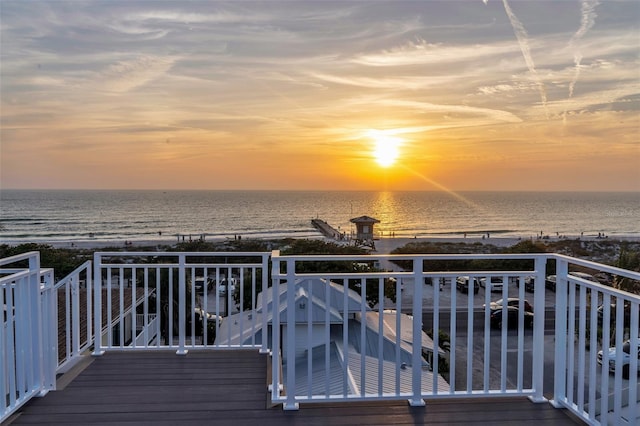 deck at dusk featuring a water view