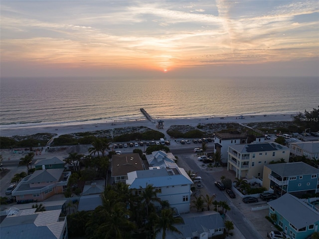 aerial view at dusk with a beach view and a water view