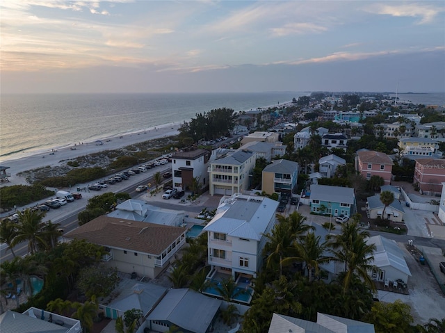 aerial view at dusk with a beach view and a water view