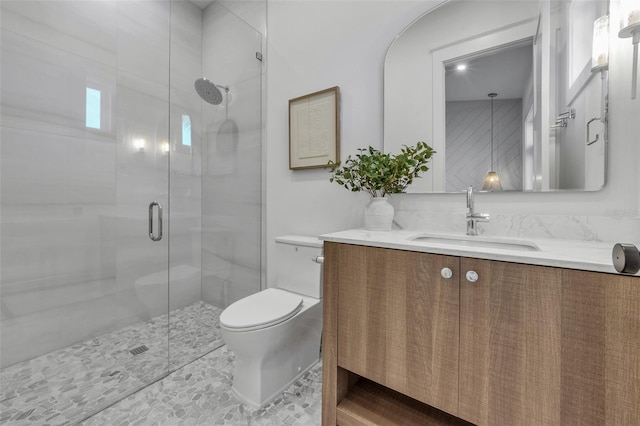 bathroom with vanity, a shower with shower door, and toilet