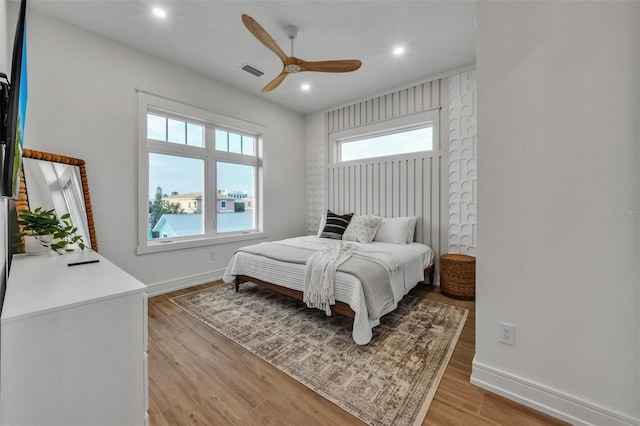 bedroom with light hardwood / wood-style floors and ceiling fan