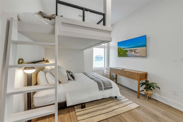 bedroom with lofted ceiling and hardwood / wood-style flooring