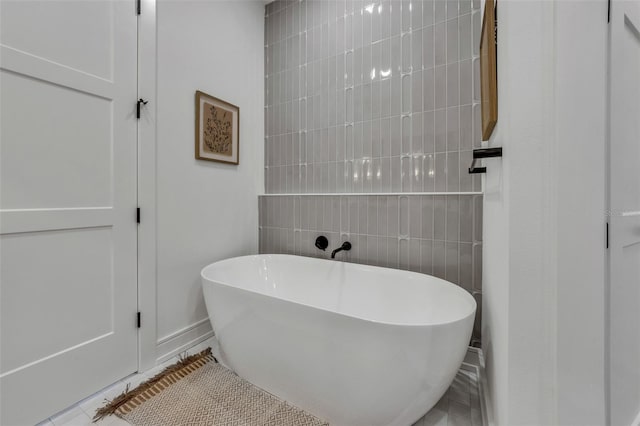 bathroom with tile patterned floors and a bathing tub