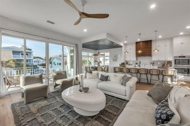 living room with ceiling fan and wood-type flooring