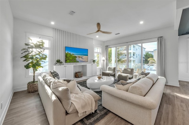 living room with ceiling fan and light hardwood / wood-style flooring