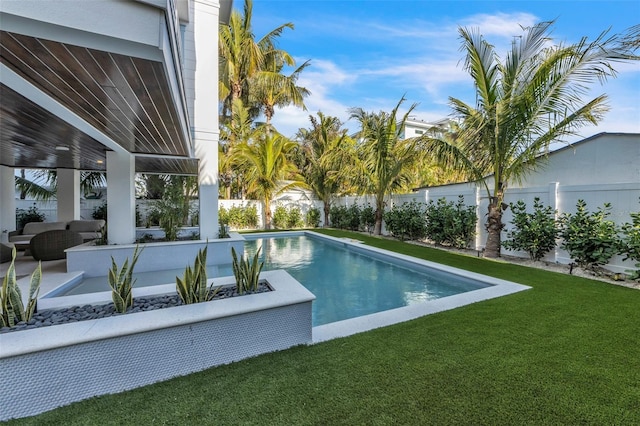 view of swimming pool with outdoor lounge area and a yard