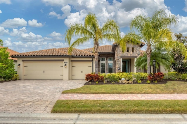 mediterranean / spanish house with a garage and a front yard