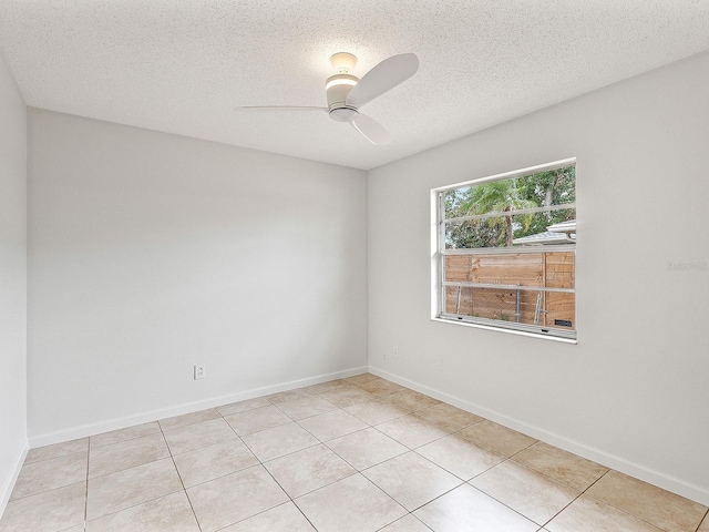 unfurnished room featuring ceiling fan, light tile patterned floors, and a textured ceiling