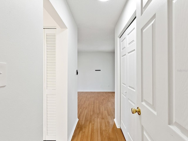 corridor with light hardwood / wood-style floors