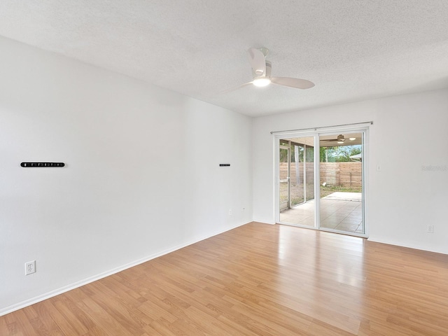 empty room with ceiling fan, light hardwood / wood-style floors, and a textured ceiling