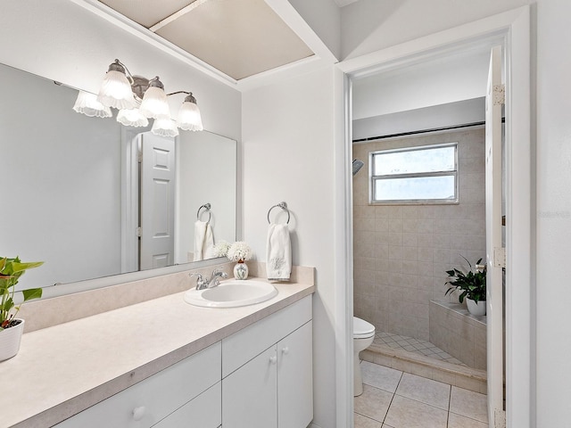 bathroom with toilet, a tile shower, vanity, and tile patterned floors