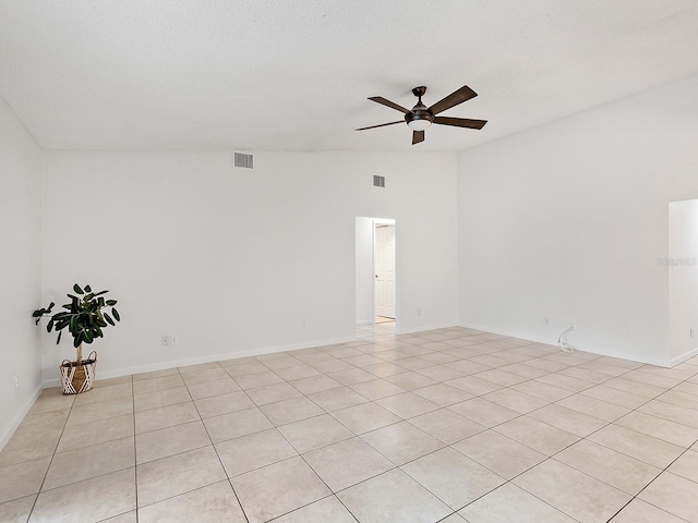 empty room featuring ceiling fan, light tile patterned floors, a textured ceiling, and lofted ceiling