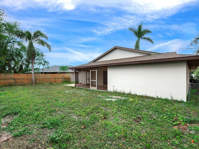 rear view of property with a yard