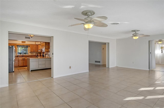 spare room featuring ceiling fan, light tile patterned floors, and crown molding