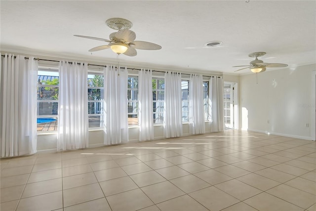 empty room with ceiling fan and light tile patterned floors