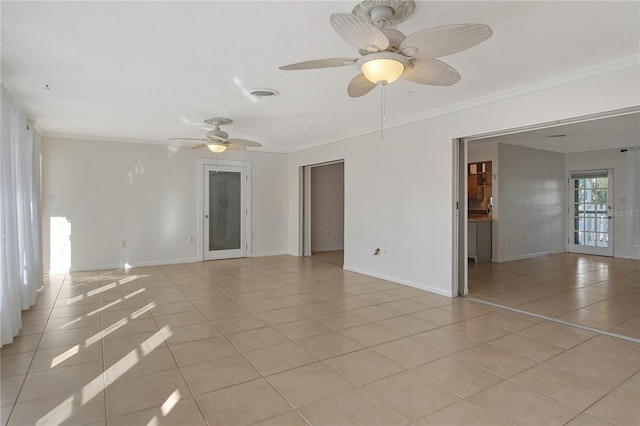 spare room with light tile patterned floors, baseboards, visible vents, and crown molding