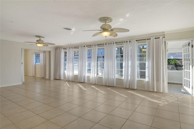 unfurnished room featuring ornamental molding, visible vents, ceiling fan, and light tile patterned floors