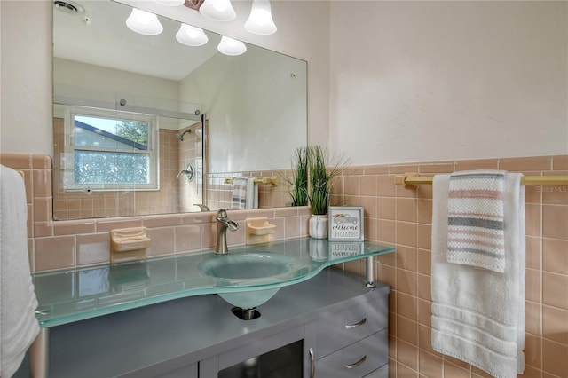 bathroom featuring visible vents, wainscoting, tile walls, and vanity