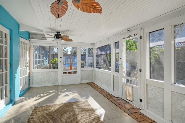 unfurnished sunroom with wood ceiling and a ceiling fan