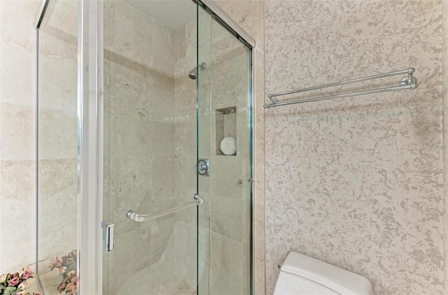 bathroom with an enclosed shower and toilet