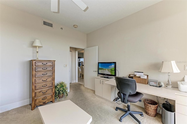 carpeted home office featuring a textured ceiling