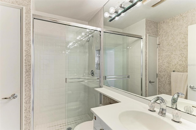 bathroom with vanity, toilet, and an enclosed shower