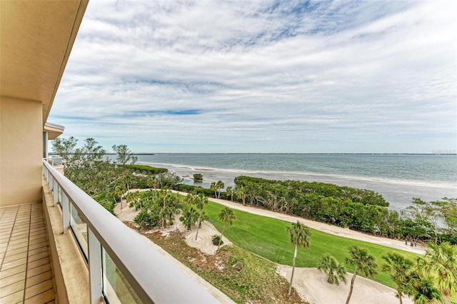 balcony with a water view and a view of the beach