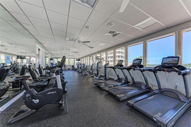 gym with a paneled ceiling and ceiling fan